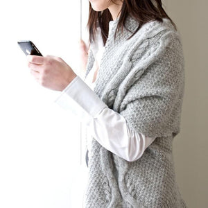 Aran cable cardigan “This cardigan is knitted in one piece and is cleverly seamed to form the innovative shape. With double moss stitch as the ground, a large interlocking cable twists up both fronts and across the shoulders in a distinctive edge to edge cardigan. British knitwear designer and sustainable yarn.